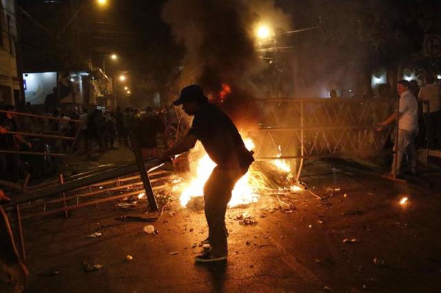 Manifestantes atacan hoy, viernes 31 de marzo de 2017, la sede del Congreso Nacional en Asunción (Paraguay). EFE