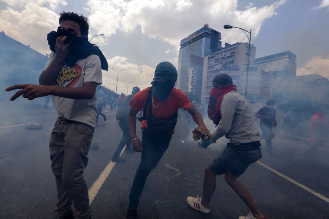 CAR01. CARACAS (VENEZUELA), 06/04/2017 - Un grupo de personas participa en una manifestación de opositores al gobierno de Nicolás Maduro hoy, jueves 6 de abril de 2017, en Caracas (Venezuela). La Policía Nacional Bolivariana (PNB) dispersó hoy con gases lacrimógenos y agua una marcha opositora en Caracas que pretendía llegar hasta la Defensoría del Pueblo para pedir su respaldo al proceso iniciado por el Parlamento contra siete magistrados del Tribunal Supremo de Justicia (TSJ). EFE/CRISTIAN HERNÁNDEZ