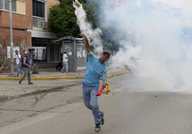 Venezuelan opposition activists clash with the police during a march against President Nicolas Maduro, in Caracas on May 1, 2017. May Day protests risk being rough in Venezuela as it marks one month since deadly clashes erupted in a political crisis with no end in sight. Protesters took to the streets from April 1 to demand elections after the courts tried to strengthen President Nicolas Maduro's grip on power. / AFP PHOTO / FEDERICO PARRA