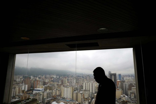 A man stands by a window at the Venezuelan Central Bank building in Caracas, Venezuela May 23, 2017. REUTERS/Carlos Barria