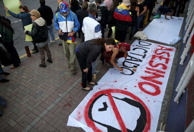 People prepare a banner that reads "Assassin dictator" during a protest against Venezuelan President Nicolas Maduro's visit to Ecuador to attend Ecuadorian President Lenin Moreno's inauguration, in Quito, Ecuador, May 23, 2017. REUTERS/Mariana Bazo