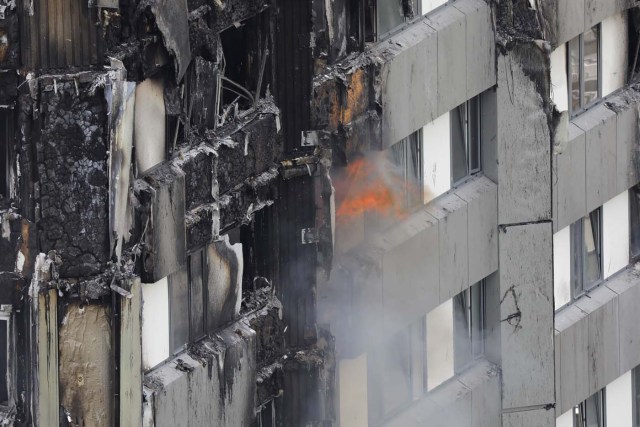 Fires still burn in Grenfell Tower, a residential tower block in west London that was caught in a huge blaze on June 15, 2017. Firefighters searched for bodies today in a London tower block gutted by a blaze that has already left 12 dead, as questions grew over whether a recent refurbishment contributed to the fire. / AFP PHOTO / Tolga AKMEN