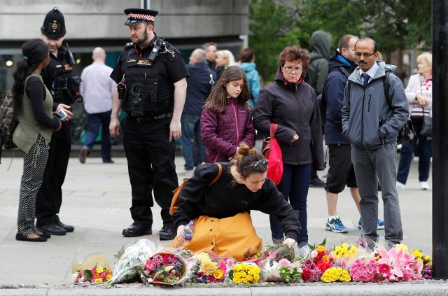 A woman leaves flowers at the south end of London Bridge, near Borough market following an attack which left 7 people dead and dozens of injured in central London, Britain, June 5, 2017. REUTERS/Peter Nicholls