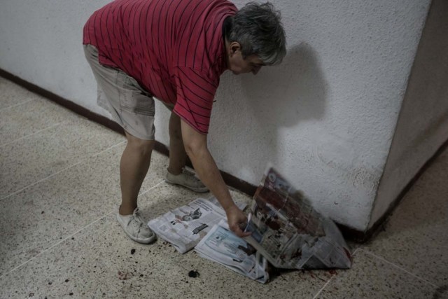 CAR01. CARACAS (VENEZUELA), 14/06/2017.- Yasmin Navarro (c) muestra la sangre de su perro Cros, al que le dispararon en las residencias Los Verdes ubicadas en el oeste de Caracas (Venezuela) hoy, miércoles 14 de junio de 2017. El oeste de Caracas fue sacudido anoche por la policía militarizada en un operativo que terminó, según el Gobierno venezolano, con la detención de 23 "terroristas" mientras que opositores aseguran hoy que se trató de una acción "terrible" en la que funcionarios causaron destrozos materiales y dispararon a mascotas. EFE/Miguel Gutiérrez