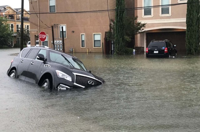 A vehicle sits half submerged in flood waters in a residential area in the aftermath of Hurricane Harvey in Houston, Texas, U.S., August 27, 2017.  REUTERS/Ernest Scheyder