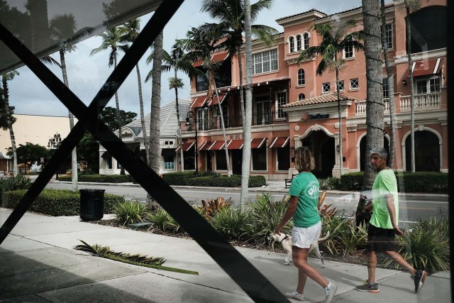 NAPLES, FL - SEPTEMBER 09: People walk through an empty downtown downtown Naples before the arrival of Hurricane Irma into Southwest Florida on September 9, 2017 in Naples, Florida. The Naples area could begin to feel hurricane-force winds from Irma by 11 a.m. Sunday and experience wind gusts over 100 mph from Sunday through Monday.   Spencer Platt/Getty Images/AFP