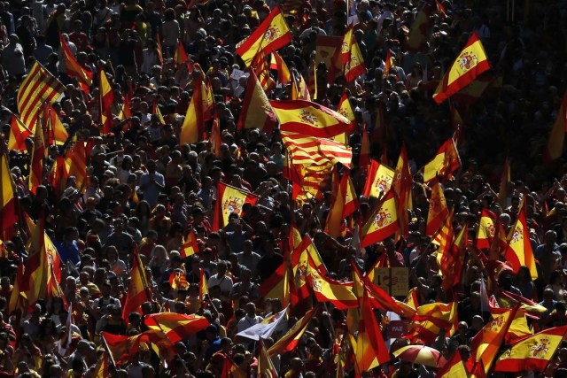 Protesters hold Spanish and Catalan flags during a demonstration called by "Societat Civil Catalana" (Catalan Civil Society) to support the unity of Spain on October 8, 2017 in Barcelona. Spain braced for more protests despite tentative signs that the sides may be seeking to defuse the crisis after Madrid offered a first apology to Catalans injured by police during their outlawed independence vote. / AFP PHOTO / PAU BARRENA