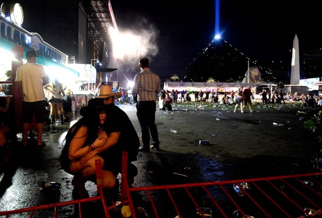 LAS VEGAS, NV - OCTOBER 01: People take cover at the Route 91 Harvest country music festival after apparent gun fire was heard on October 1, 2017 in Las Vegas, Nevada. There are reports of an active shooter around the Mandalay Bay Resort and Casino. David Becker/Getty Images/AFP