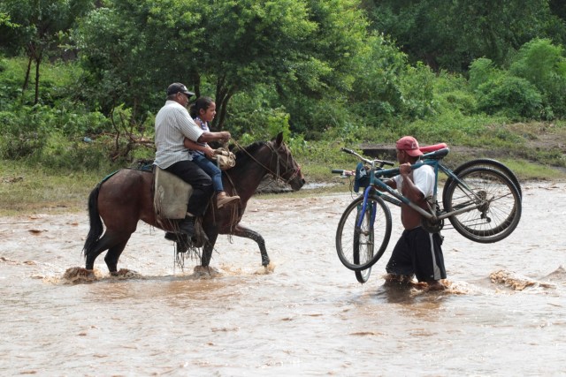 Local residents cross a river flooded by heavy rains by Tropical Storm Nate in Nandaime town, Nicaragua October 6, 2017. REUTERS/Oswaldo Rivas