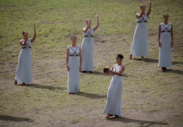 Olympics - Lighting Ceremony of the Olympic Flame Pyeongchang 2018 - Ancient Olympia, Olympia, Greece - October 24, 2017 Actresses with the flame during the Olympic flame lighting ceremony for the Pyeongchang 2018 Winter Olympics REUTERS/Costas Baltas