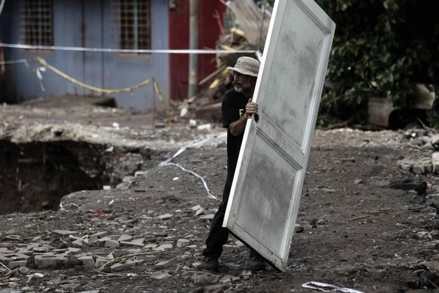 SJS13. SAN JOSÉ (COSTA RICA), 06/10/2017.- Un hombre carga una puerta entre los escombros hoy, viernes 6 de octubre de 2017, en la localidad del Barrio Los Anonos, en el cantón de Escazú, al oeste de San José (Costa Rica), tras el paso de la tormenta tropical Nate. Las autoridades de Costa Rica confirmaron que la cifra de fallecidos a causa de las lluvias provocada por la tormenta tropical Nate ha ascendido hoy a nueve, mientras que hay 25 desaparecidos. La Comisión Nacional de Emergencias (CNE) indicó que hay un total de 7.000 evacuados y han habilitado 95 albergues para las personas que se han visto obligadas a salir de su hogar. EFE/Jeffrey Arguedas