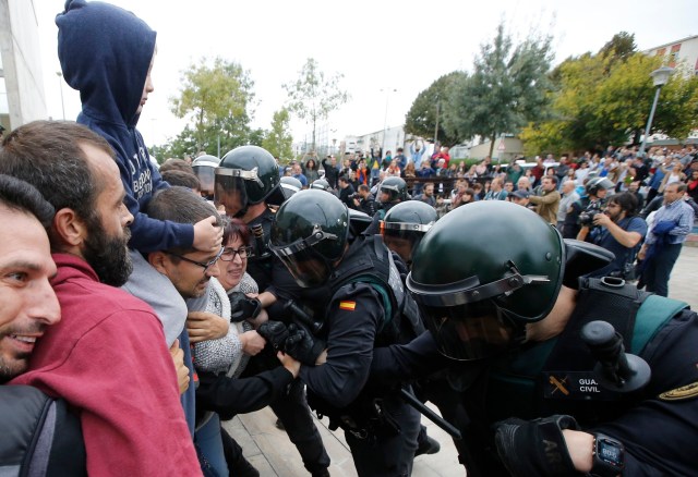 People clash with Spanish Guardia Civil guards outside a polling station in Sant Julia de Ramis, where Catalan president was supposed to vote, on October 1, 2017, on the day of a referendum on independence for Catalonia banned by Madrid. More than 5.3 million Catalans are called today to vote in a referendum on independence, surrounded by uncertainty over the intention of Spanish institutions to prevent this plebiscite banned by justice. / AFP PHOTO / Raymond ROIG