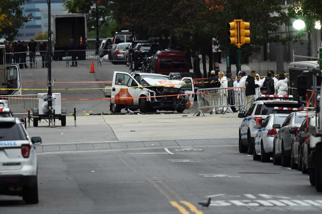 Investigators work around the wreckage of a Home Depot pickup truck a day after it was used in a terror attack in New York on November 1, 2017. The pickup truck driver who plowed down a New York cycle path, killing eight people, in the city's worst attack since September 11, was associated with the Islamic State group but "radicalized domestically," the state's governor said Wednesday. The driver, identified as Uzbek national named Sayfullo Saipov was shot by police in the stomach at the end of the rampage, but he was expected to survive. / AFP PHOTO / Jewel SAMAD