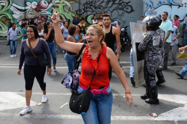 People shout slogans during a protest against the shortage of food, amid Fuerzas Armadas avenue in Caracas on December 28, 2017. As Venezuelans protest in Caracas demanding the government's prommised pork -the main dish of the Christmas and New Year's dinner-, President Nicolas Maduro attributes the shortage to international sabotage. / AFP PHOTO / FEDERICO PARRA