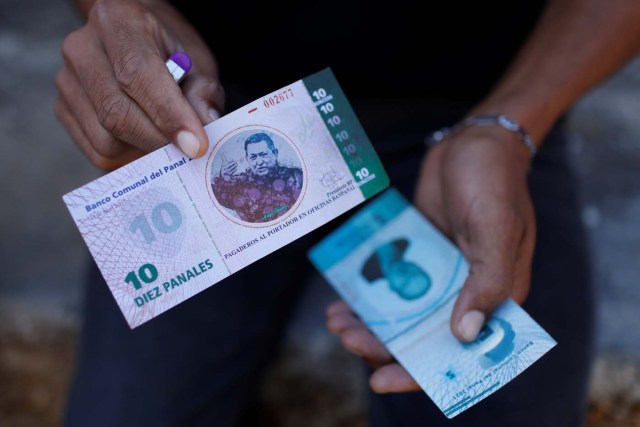 A man shows a 10 Panal note depicting Venezuela's late President Hugo Chavez outside a branch of BanPanal communal bank in Caracas, Venezuela December 15, 2017. REUTERS/Marco Bello