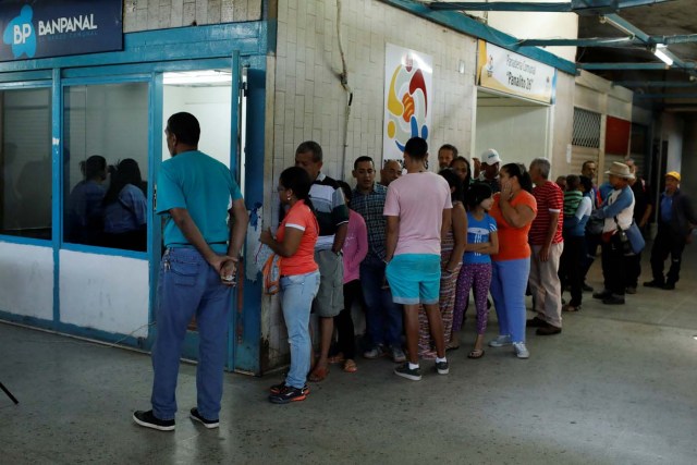 People line up outside a branch of BanPanal communal bank in Caracas, Venezuela December 15, 2017. REUTERS/Marco Bello