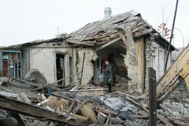 Una mujer inspecciona su vivienda destruida después de que fuera bombardeada por rebeldes pro-rusos en la ciudad controlada de Yasinovátaya, en Donetsk (Ucrania) hoy, 21 de diciembre de 2017. Al menos dos personas han muerto y otras han resultado heridas. El representante especial para Ucrania de la OSCE, Martin Sajdik, ha dicho que los miembros del Grupo de Contacto Trilateral abogó por la instrucción de medidas disciplinarias para las violaciones del alto el fuego en Donbas. EFE/ Alexander Ermochenko