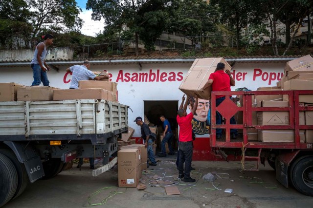 CAR109. CARACAS (VENEZUELA), 28/12/2018.- Un grupo de personas adeptas al oficialismo saca juguetes de una Casa de Asambleas del Poder Popular para repartirlos en el sector La Vega, después de que este recinto fuese asediado por manifestantes en horas de la madrugada hoy, jueves 28 de diciembre del 2017, en Caracas (Venezuela). Durante la madrugada de este jueves se registraron en varios puntos de Venezuela protestas por la escasez de alimentos para completar el menú navideño, gas y agua, informaron hoy medios locales. EFE/MIGUEL GUTIÉRREZ