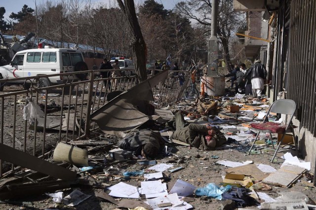 EDITORS NOTE: Graphic content / Afghan volunteers carry bodies at the scene of a car bomb exploded in front of the old Ministry of Interior building in Kabul on January 27, 2018. An ambulance packed with explosives blew up in a crowded area of Kabul on January 27, killing at least 17 people and wounding 110 others, officials said, in an attack claimed by the Taliban. / AFP PHOTO / WAKIL KOHSAR