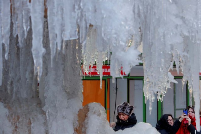 Una mujer se detiene para fotografiar la fuente conmemorativa congelada Josephine Shaw Lowell en Nueva York, Estados Unidos, el 3 de enero de 2018. REUTERS / Lucas Jackson