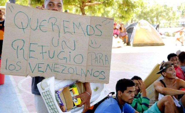 CUC04. CÚCUTA (COLOMBIA), 22/01/2018.- Un venezolano parte del grupo de personas que se tomaron un polideportivo de un barrio de la ciudad de Cúcuta (Colombia) muestra un cartel en el que pide un refugio para sus compatriotas hoy, lunes 22 de enero de 2018. Las autoridades locales dieron un plazo de dos días a los venezolanos para que desalojen este lugar. EFE/SCHNEYDER MENDOZA
