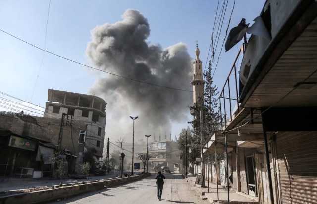 A picture taken on February 21, 2018 shows a smoke plume rising following a reported regime air strike in the rebel-held enclave of Hamouria in the Eastern Ghouta near Damascus. / AFP PHOTO / ABDULMONAM EASSA