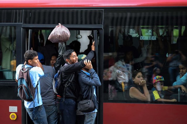 Locals use public transportation buses during a partial power cut in Caracas on February 6, 2018. / AFP PHOTO / FEDERICO PARRA