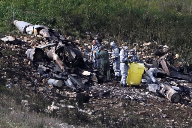 Israeli security forces examine the remains of an F-16 Israeli war plane near the village of Harduf, Israel February 10, 2018. REUTERS/Ronen Zvulun