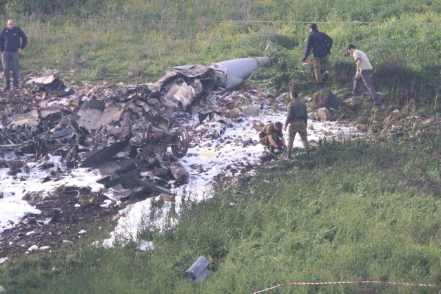 Israeli security forces walk next to the remains of an F-16 Israeli war plane near the Israeli village of Harduf, Israel February 10, 2018. REUTERS/Herzie Shapira ISRAEL OUT. NO COMMERCIAL OR EDITORIAL SALES IN ISRAEL. NO RESALES. NO ARCHIVES TPX IMAGES OF THE DAY