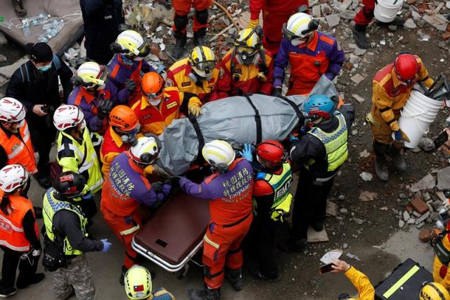 Los equipos de rescate recuperan el cadáver de una víctima de entre los escombros de un edificio derrumbado tras el terremoto de 6,4 grados en la escala Richter que sacudió la isla de Taiwán el pasado martes, en Hualien, hoy, 9 de febrero de 2018. De momento, se han registrado 10 muertos y 275 heridos, mientras que siete personas permanecen desaparecidas, según las últimas cifras divulgadas. EFE/ Ritchie B. Tongo