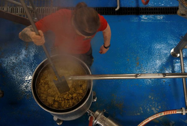 Un trabajador extrae líquido de una maceración y salta en la cervecería Windsor and Eton en Windsor, Gran Bretaña, el 11 de abril de 2018. Fotografía tomada el 11 de abril de 2018. REUTERS / Peter Nicholls