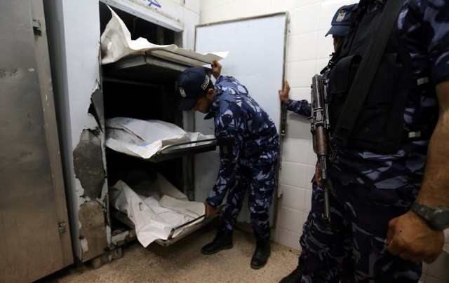 ATTENTION EDITORS - VISUAL COVERAGE OF SCENES OF INJURY OR DEATH Palestinian Hamas police officers stand next to the bodies of Hamas gunmen, who were killed in an explosion, at a hospital morgue in the central Gaza Strip May 5, 2018. REUTERS/Ibraheem Abu Mustafa