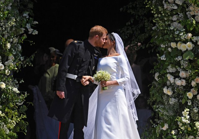 Britain's Prince Harry (L) and Meghan Markle (R) kiss as they exit St George's Chapel in Windsor Castle after their royal wedding ceremony, in Windsor, Britain, 19 May 2018. The couple have been bestowed the royal titles of Duke and Duchess of Sussex on them by the British monarch. NEIL HALL/Pool via REUTERS