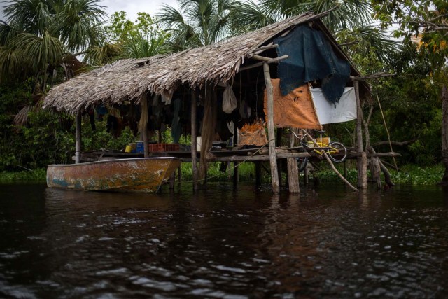 Fotografía fechada el 10 de mayo de 2018 que muestra un palafito (vivienda de la etnia Warao) en la ribera del río Morichal, en Maturín (Venezuela). Unos 120 indígenas distribuidos en cerca de 30 palafitos de precaria elaboración conforman la comunidad de Morichal Largo, un asentamiento de la etnia Warao ubicado en el sur de Venezuela, que resiste debajo de un puente la miseria e insalubridad propia de la crisis nacional. EFE/Cristian Hernández