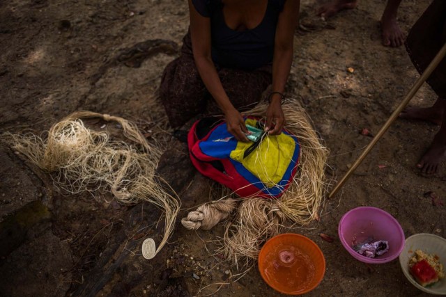 Fotografía fechada el 10 de mayo de 2018 que muestra a una mujer de la etnia Warao mientras cuenta dinero en efectivo, en Maturín (Venezuela). Unos 120 indígenas distribuidos en cerca de 30 palafitos de precaria elaboración conforman la comunidad de Morichal Largo, un asentamiento de la etnia Warao ubicado en el sur de Venezuela, que resiste debajo de un puente la miseria e insalubridad propia de la crisis nacional. EFE/Cristian Hernández