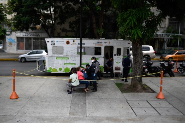 Miembros del grupo paramédico de la ONG “Ángeles de las vias” ayudan a una persona en su sede, una autocaravana, en el barrio de Los Palos Grandes, en Caracas, el 10 de junio de 2020, en medio de la nueva pandemia de coronavirus COVID-19. 